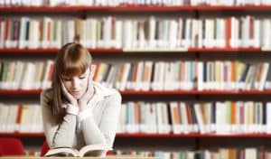 Femme qui lit dans une bibliothèque