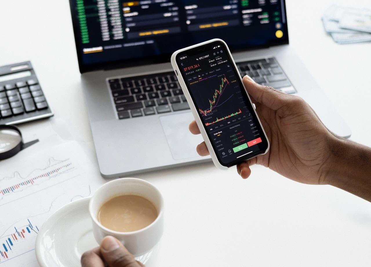 personne tenant smartphone investissement trading